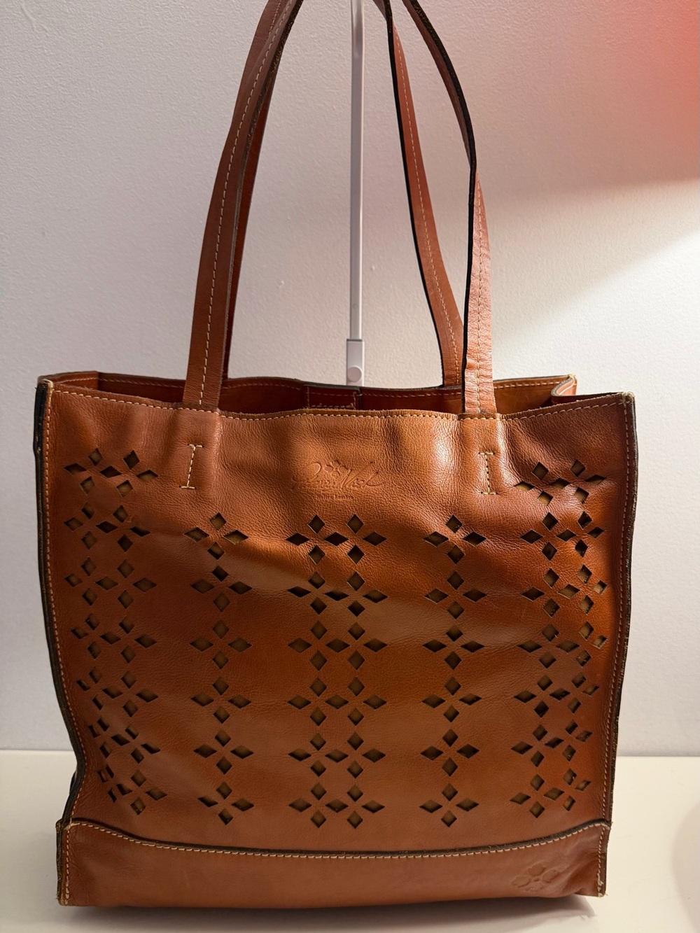 Patricia Nash brown/cognac tote with geometric laser cut pattern.